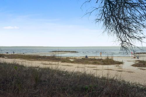 a beach with people playing in the water at Unspoiled Beachfront Villa Sunrises from Balcony in Hilton Head Island
