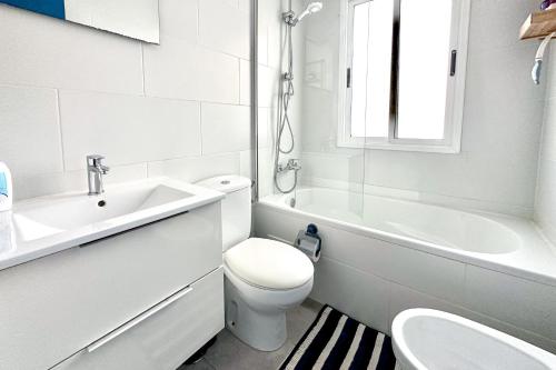 a white bathroom with a toilet and a sink at Apartment La Perla, Los Cristianos in Los Cristianos