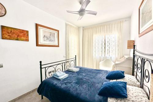 a bedroom with a blue bed with a ceiling fan at Apartment La Perla, Los Cristianos in Los Cristianos