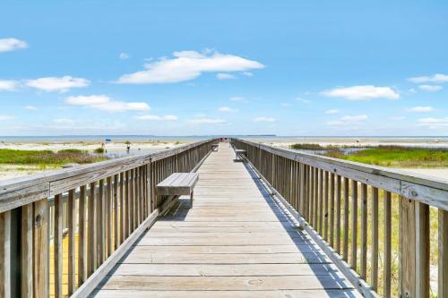 a wooden boardwalk to the beach with a bench on it at Unspoiled Beachfront Villa Sunrises from Balcony in Hilton Head Island