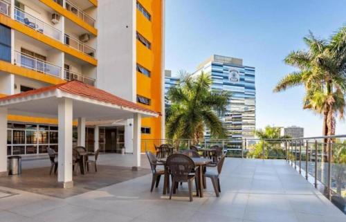a balcony with tables and chairs and a building at Garvey Hotel - Flat centro de Brasília in Brasilia