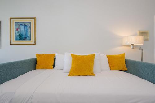 a bed with yellow and white pillows on it at Phoenix II 2151 condo in Romar Beach