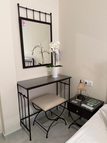 a black desk with a chair and a mirror at Paradise Garden Paros in Piso Livadi