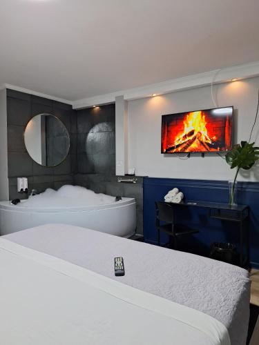 a bedroom with a bed and a tub and a tv at Hotel Asturias in Viña del Mar