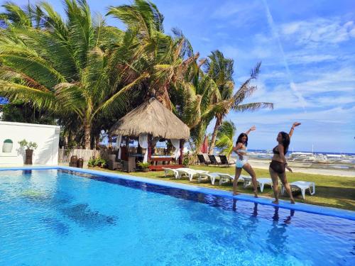 two women are playing in the water in a swimming pool at Bohol South Beach Hotel in Panglao