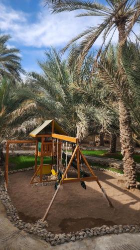 a playground in front of a palm tree at Casa Blanca - calm space for soul revival in Ādam