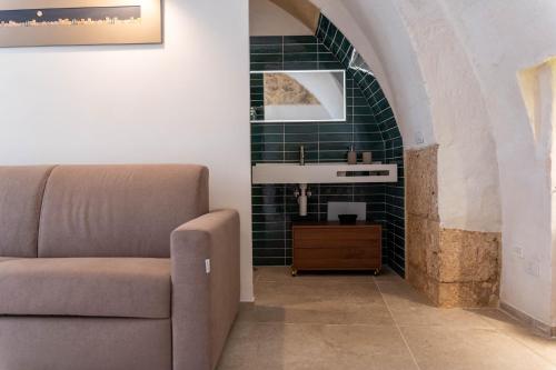 un soggiorno con divano e lavandino di Casa Tre Archi - Malva ad Altamura
