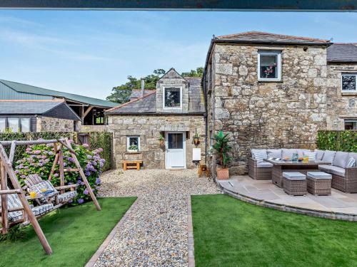 a garden with a stone house with a patio at 4 Bed in Lanhydrock 90215 in Bodmin
