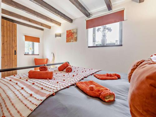 a bedroom with a bed with orange pillows on it at 4 Bed in Lanhydrock 90215 in Bodmin