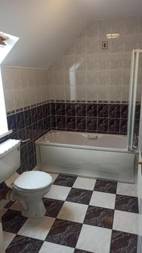 a bathroom with a toilet and a tub and a sink at Coastal Breeze holiday home Enniscrone in Enniscrone