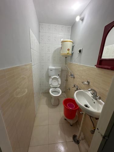 a bathroom with a toilet and a sink at Pearl Homestay Mussoorie in Mussoorie