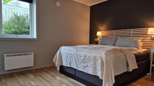 a bedroom with a large bed and a window at Teientoppen Apartment in Larvik