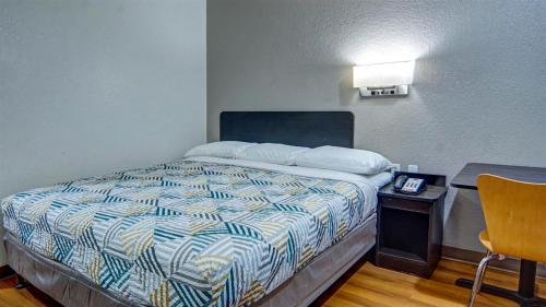 a small bedroom with a bed and a desk at Motel 6-Longview, TX in Longview