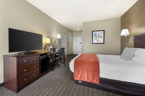 a hotel room with a bed and a flat screen tv at Best Western Plus Winslow Inn in Winslow