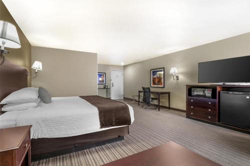 a hotel room with a bed and a flat screen tv at Best Western Plus Winslow Inn in Winslow
