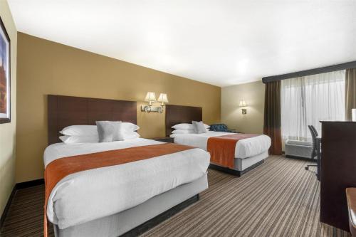 a hotel room with two beds and a window at Best Western Plus Winslow Inn in Winslow