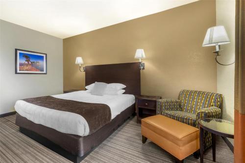 a hotel room with a bed and a chair at Best Western Plus Winslow Inn in Winslow