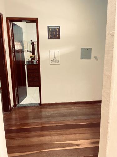 a hallway with a mirror and a clock on the wall at Rico Hostel in Cabo Frio