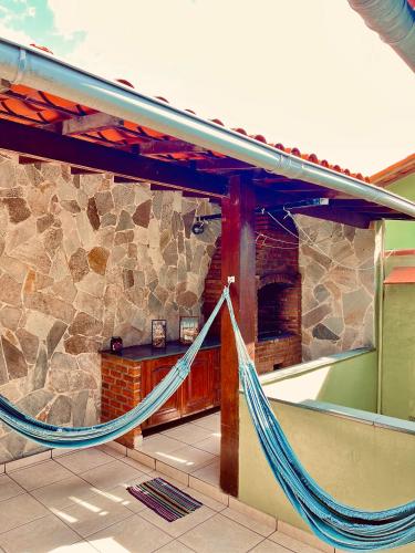 a porch with a hammock in front of a building at Rico Hostel in Cabo Frio