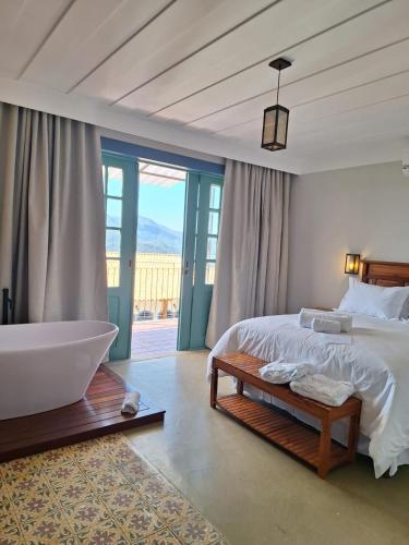 a bedroom with a large bed and a bath tub at La Villa Novas Pousada in Lavras Novas