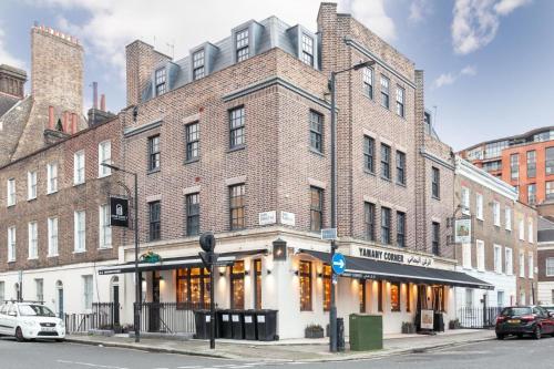 a large brick building on the corner of a street at London Paddington Apartments in London