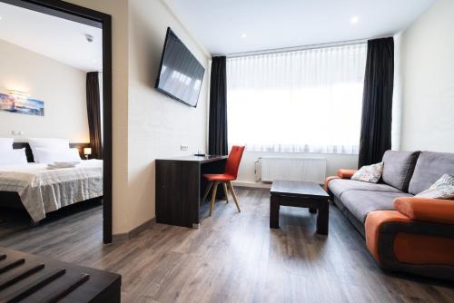 a living room with a couch and a bed at home Hotel in Wilhelmshaven