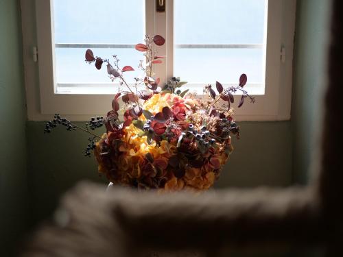 a vase filled with flowers sitting in a window at La Casa Della Seta in Mezzegra
