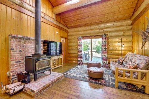 a living room with a fireplace in a log cabin at Private Deck Dog-Friendly Arlington Cabin in Arlington