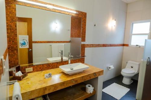 a bathroom with a sink and a toilet and a mirror at Finca Catalina Hotel Boutique in Tepoztlán