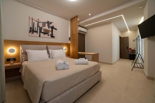 a bedroom with a large bed with towels on it at Centre Ville Local Stays in Argos