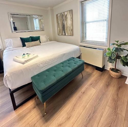 ein Schlafzimmer mit einem großen Bett und einer grünen Ottomane in der Unterkunft 1BR 7-O - Cozy Downtown Atlanta Condo in Atlanta