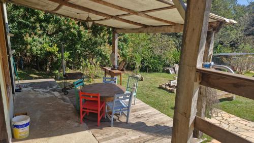 a wooden table and chairs under a wooden pergola at Pe na Pedra quarto 1 in Atibaia