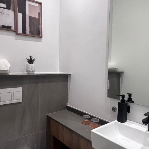 a bathroom with a sink and a mirror at 423 Menlyn maine Apartment in Pretoria