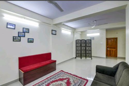 a living room with a red couch and a rug at The Bliss 2 bh flat in Shādipur