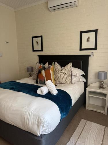 a bedroom with a large bed with pillows on it at Rivonia Garden Suites in Johannesburg