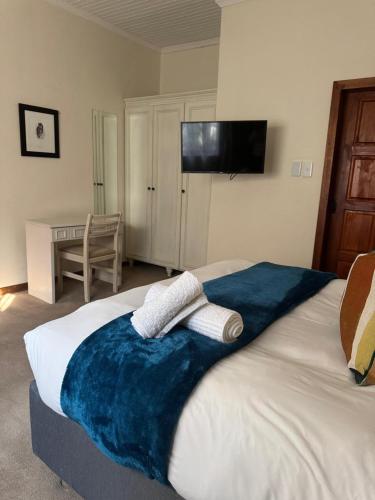a bedroom with a bed with two towels on it at Rivonia Garden Suites in Johannesburg