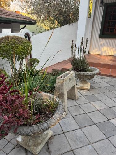 two stone vases with plants on a patio at Rivonia Garden Suites in Johannesburg