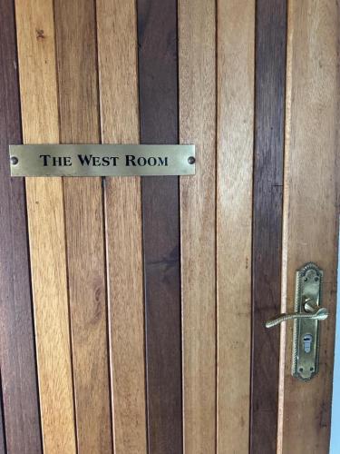 a sign that reads the west room on a wooden door at Rivonia Garden Suites in Johannesburg