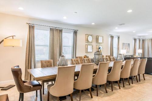 a dining room with a long table and chairs at Elegant Home Near Disney With Private Pool And Waterpark & Resort Access At Encore Resorts Reunion - 391Fl in Kissimmee