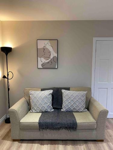 a couch in a living room with a picture on the wall at The Hideaway Carrickfergus in Carrickfergus