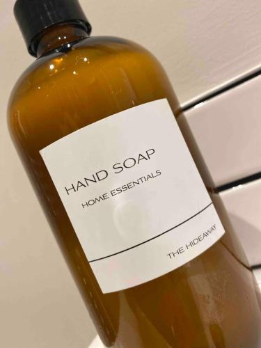 a bottle of hand soap with a sign on it at The Hideaway Carrickfergus in Carrickfergus