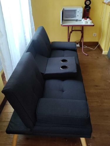 a blue couch in a living room with a table at 2 pièces à Boulogne sur Gesse in Boulogne-sur-Gesse