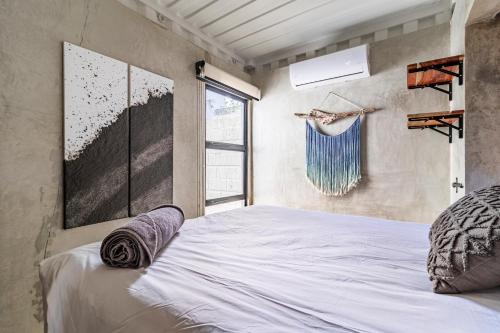 a bedroom with a large white bed with a window at Z102 Studios, 4 Industrial Beach Condos w Pool! in Playa Flamingo