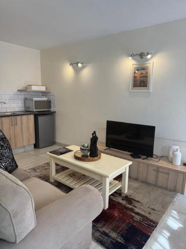 a living room with a tv and a coffee table at Rivonia Garden Suites in Johannesburg