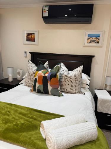 a bedroom with a large bed with a green blanket at Rivonia Garden Suites in Johannesburg