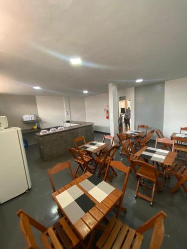 an empty cafeteria with tables and chairs and a refrigerator at Hotel Amazonas in Canaã dos Carajás