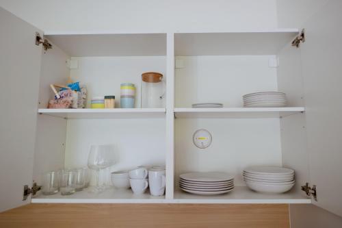 a white cabinet with plates and dishes in it at Apartmán Denisa in Rokytnice nad Jizerou