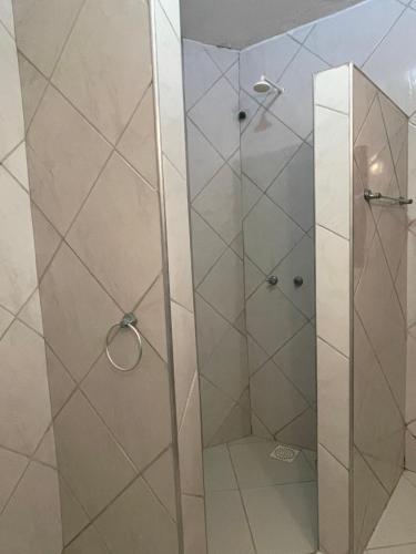 a shower with a glass door in a bathroom at Casa Redonda in Beberibe