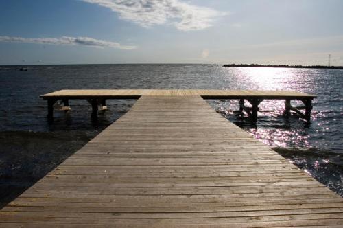 einem hölzernen Pier mit einer Bank auf dem Wasser in der Unterkunft Kalana Holiday Resort in Kalana