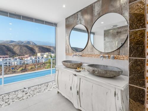 Dos lavabos en un baño con una gran ventana. en Villa Serena Find Luxury & Serenity in Tenerife, en Palm-mar